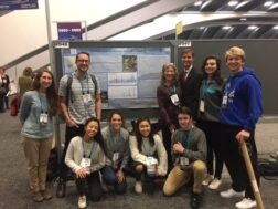 Students and educators in front of scientific poster